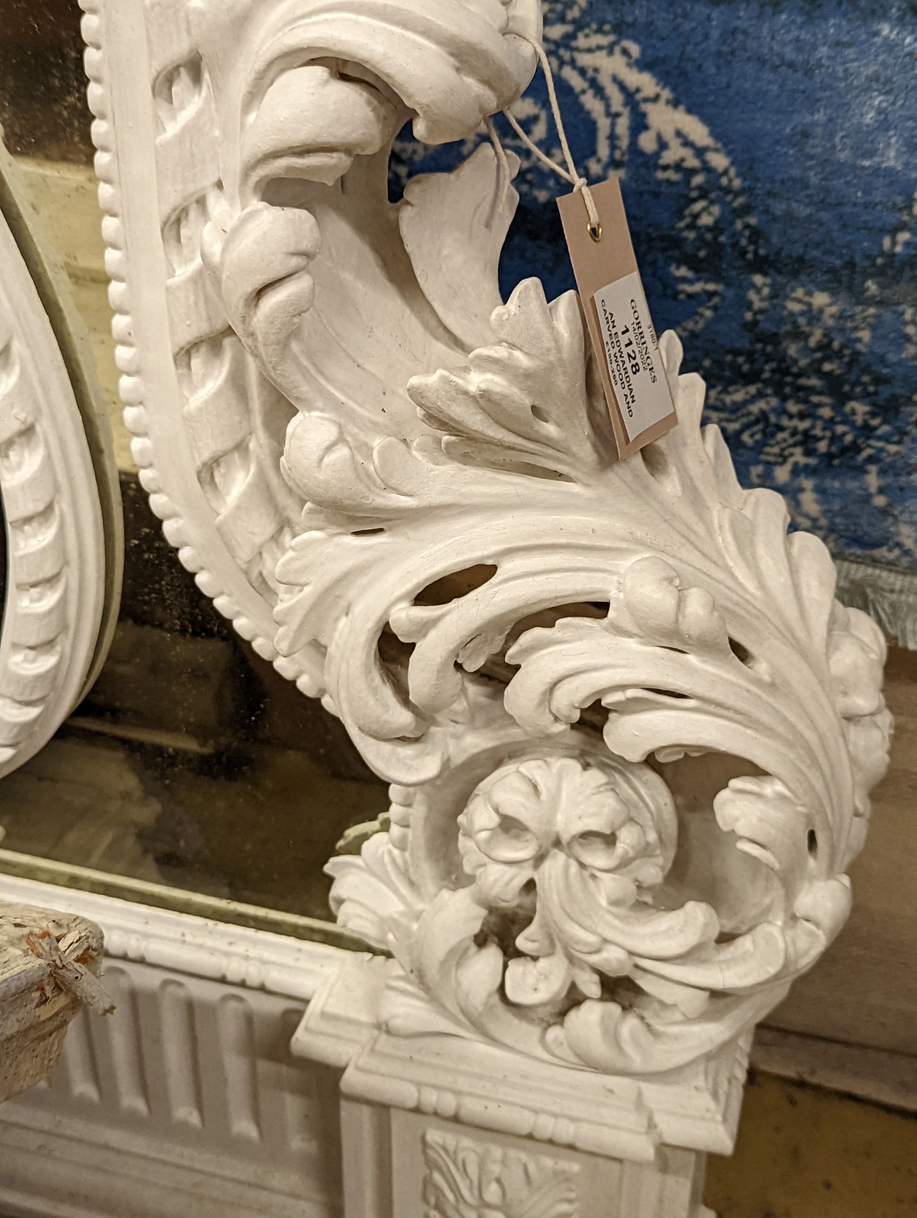 An Edwardian carved wood and gesso overmantel with cherub surmount, later painted white, width 188cm, height 96cm and a two white painted door pediments in need of restoration